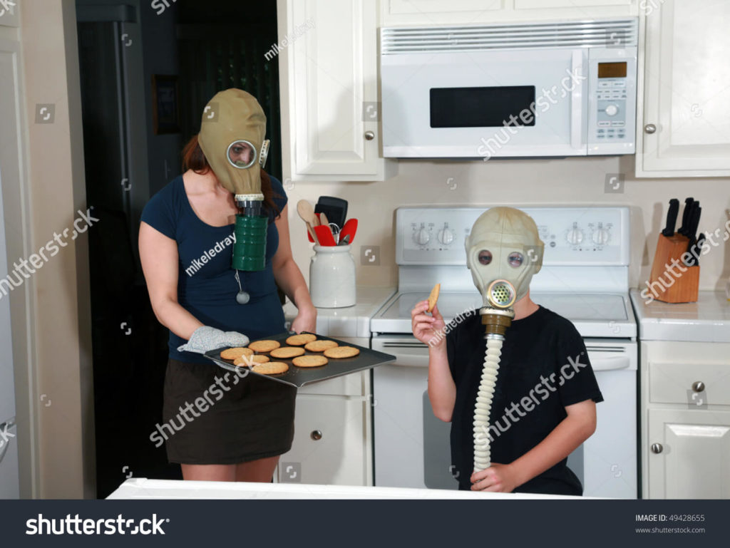 weird-stock-photo-mother-son-enjoy-peanut-butter-cookies-in-kitchen-wearing-masks